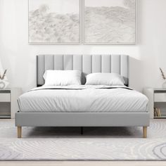 a bed with two paintings above it in a white and gray bedroom setting, along with a rug on the floor