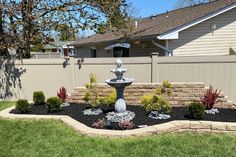 a small fountain in the middle of a flower bed