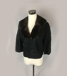 "A vintage rayon ribbon knit  jacket in black with a brown mink shawl collar. The knit is in florals and swirls with notched back hem and cuffs. The sleeves are 3/4. The jacket is fully lined and the fur collar is attached with snaps for removal and easy dry cleaning. It closes with a hidden hook and eye at the base of the collar. The label reads, \"Ribbon Knit Original by Dolly Muff Mfg. Co.\" The jacket measures 36\" around the bust, the shoulders are 14\" across, the sleeves are 15\" and the Retro Fall Evening Outerwear, Retro Evening Outerwear For Fall, Brown Winter Evening Outerwear, Vintage Winter Evening Outerwear, Vintage Outerwear For Evening In Fall, Vintage Winter Cardigan For Evening, Vintage Cardigan For Evening In Winter, Vintage Winter Evening Cardigan, Vintage Evening Cardigan For Winter