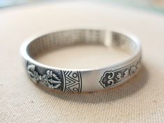 "This is a Tibetan mantra cuff bracelet with engraving of Vajra Symbol, Om Mani Padme Hum mantra and The Heart Sutra. 999 fine silver is as close as you can get to pure silver. Because this meditation bangle consists of 99.9% pure silver, it is highly resistant to tarnish. Vajra is a symbolic ritual tool that is used in Buddhism, Hinduism, and Jainism to represent the unyielding power of spirit. It is a Sanskrit word that means 'thunderbolt'. Vajra is a classic symbol, symbolizes the striking an Spiritual Etched Silver Bracelet, Spiritual Sterling Silver Cuff Bracelet, Traditional Hand-strung Bracelets For Meditation, Spiritual Silver Engraved Cuff Bracelet, Tibetan Bracelet Buddha Groove, Tibetan Mantra, Heart Sutra, Mantra Bracelet, Om Mani Padme Hum