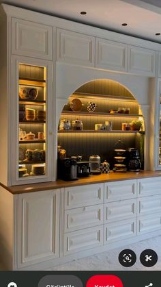 a kitchen with white cabinets and shelves filled with food