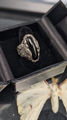 Vintage Sterling Silver Onyx stone and Butterfly Ring  This dazzling vintage ring is the perfect accessory to make your look take flight! It features a sterling silver band with an Onyx stone centerpiece, exquisitely carved with engraved butterflies. A piece of timeless craftsmanship, with just a touch of whimsy! Vintage Sterling Silver Onyx stone and Butterfly Ring details: Made of a sterling silver features unique oval shaped onyx stone center flanked by two beautiful profiles of butterflies. Silver Gift Wrap, Peep Toe Shoes, Butterfly Ring, Silver Gifts, Onyx Stone, Vintage Ring, Sterling Silver Bands, Silver Band, Rings Statement