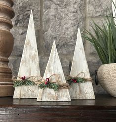 three small wooden christmas trees on a table