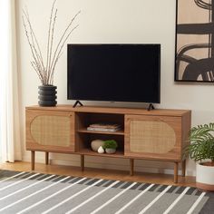 a flat screen tv sitting on top of a wooden entertainment center in a living room