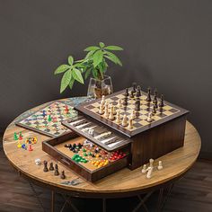 a wooden table topped with chess pieces and a plant