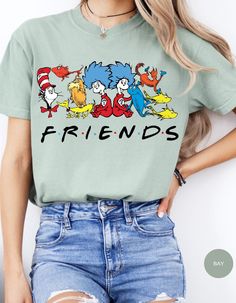 Join the whimsical world of Dr. Seuss with our Seuss Squad Friends Tee! Featuring beloved characters from the enchanting stories of Dr. Seuss, this shirt brings a splash of nostalgia and fun to your wardrobe. Made from soft, premium cotton, it offers all-day comfort and durability. Whether you're a lifelong fan or introducing these classic tales to a new generation, this tee is perfect for showing off your Seuss spirit. Ideal for casual outings, school, or cozy days at home, the Seuss Squad Friends Tee is a delightful addition to any Seuss lover's collection. Embrace the joy and magic of Dr. Seuss with this charming and colorful shirt! Playful Character Print T-shirt With Relaxed Fit, Spring Crew Neck Shirt With Character Print, Pop Culture Green Tops With Letter Print, Themed Cotton Shirt With Cartoon Print, Themed Cotton Short Sleeve Tops, Themed Cartoon Print Crew Neck T-shirt, Themed Cotton T-shirt With Letter Print, Themed Pre-shrunk Cotton T-shirt, Themed Cotton Crew Neck T-shirt