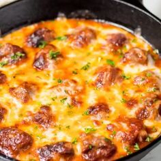 a skillet filled with cheese and meatballs