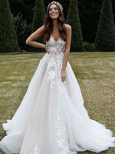 a woman in a wedding dress standing on the grass