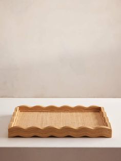 a rectangular bamboo tray with wavy lines on the bottom and sides, sitting on a white surface