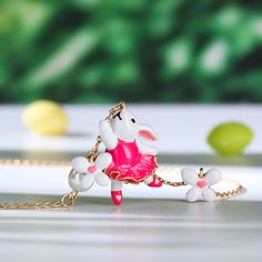 How cute is this pink bunny rabbit necklace accented with cultured pearls and white enamel flowers? Spring is in the air every day with this beautiful necklace, perfect for Easter gifting and hand enamelled, set on an gold plated sterling silver necklace. The ideal accessory to kick off your Spring, Summer look.Carat Weight: 1.5 ctStone Size: 6 mmNumber of Stones: 1 Stone Color: Diamond WhiteStone Shape: RoundWeight: 4.9 gWidth: 16 mmHeight: 23 mmThickness: 7.7 mmPlating Color: Yellow GoldLength Whimsical White Jewelry For Valentine's Day, Whimsical White Pendant Jewelry, Pink Jewelry For Easter Gift, Whimsical White Pendant Necklace, Rabbit Necklace, Dreamy Garden, Enamel Flowers, Rabbit Necklaces, Spring Is In The Air