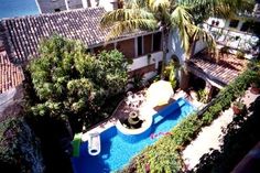 an aerial view of a house with a pool and palm trees in the foreground