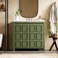 a bathroom with a green cabinet and mirror