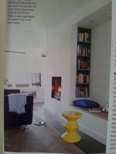 an article in the magazine shows a living room with bookshelves and a fireplace