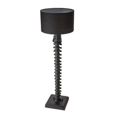 a lamp that is sitting on top of a wooden base with a black shade over it