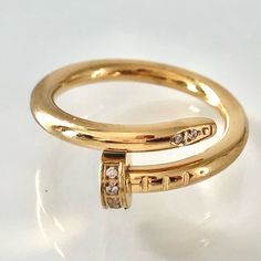 a gold ring with two diamonds on it's sides, sitting on a white surface