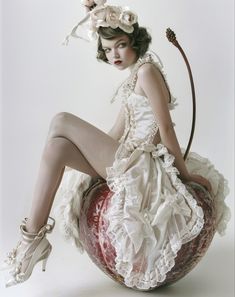 a woman in white dress sitting on top of an apple