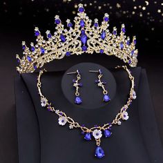 a tiara and earring set with blue crystal stones on a black tablecloth