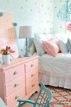 a bedroom with pink furniture and gold polka dot wallpaper