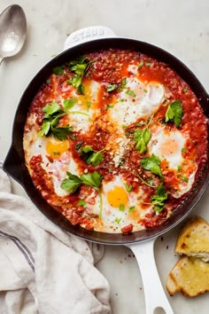 an egg dish in a skillet with bread on the side