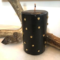 a black candle with gold stars on it