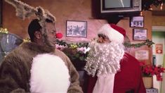 two men dressed up as santa claus and rudolph the red nosed reindeer are talking to each other