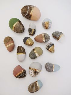 several different types of rocks on a white surface with gold and silver foiled edges