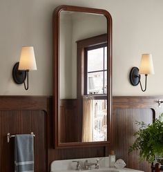 a bathroom sink sitting under a mirror next to a wall mounted faucet in front of a window