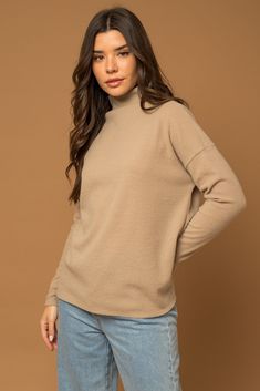 Slip into luxurious softness and effortless style with this mock neck knit top. Crafted from a sumptuous neutral-hued fabric blend, this lightweight yet cozy long-sleeve top is your new wardrobe workhorse. Its ribbed knit clings in all the right places for a flattering, customized fit while the mock neckline provides just the right amount of coverage. Perfect for transitional weather, this top layers beautifully under jackets but also stands stylishly on its own. Versatile yet distinctive, this Chic Knit Turtleneck For Spring, Chic Spring Knit Turtleneck, Trendy Turtleneck Knit Top For Fall, Knit Turtleneck Mock Neck Top For Fall, Knit Long Sleeve Turtleneck For Spring, Chic Ribbed Turtleneck For Fall, Spring Cozy Ribbed Turtleneck, Fall Knit Mock Neck Turtleneck Top, Knit Mock Neck Top For Fall Layering