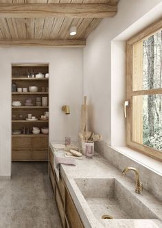 a large kitchen with two sinks and wooden cabinets in the center, along with open shelving