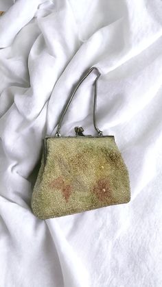 This stunning vintage evening bag from the 1950s is adorned with sequins and beads, showcasing the elegance and style of the era. It features a silky fabric lining and a clasp fastener, along with a short chain handle. The trend for small, uniquely shaped bags became very popular in the mid-1950s, and this bag is a perfect example. Designed to hold essentials like beauty products and cigarettes, it was a staple for daytime and evening wear alike. Please note that this is a pre-loved vintage item Vintage Evening Bags, Silky Fabric, Vintage Wear, Clutch Handbag, Vintage 1950s, Evening Wear, Evening Bags, Vintage Collection, Purses And Handbags