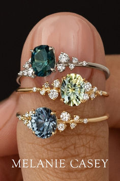 three rings with different colored stones on them