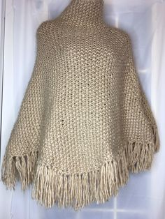 Rue21 Crochet Knitted Beige Poncho With High Neck And Fringe One Size Fits All. Made with chunky acrylic yard From top of neck to bottom of fringe measures 32” Neck opening measures 9.5” Widest Measures 38” Condition is Pre-owned. Thanks for looking Hand Knitted Beige Poncho For Fall, Hand Knitted Beige Poncho For Winter, One Size Beige Bohemian Poncho, Beige Crochet Poncho For Fall, Beige Knit Poncho, Beige Knit Poncho One Size, Fall Crochet Beige Poncho, Beige Fringe Shawl Poncho, Hand-knitted Beige Poncho For Winter