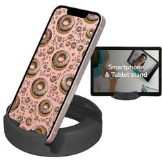 an iphone and tablet stand with doughnuts on it, next to a cell phone