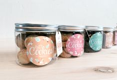 three jars filled with cookies sitting on top of a wooden table next to each other