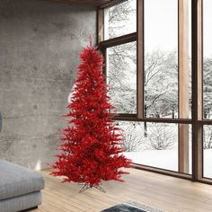 a living room with a couch and a red christmas tree in front of a large window