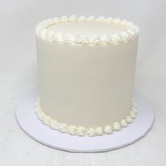 a white frosted cake sitting on top of a plate