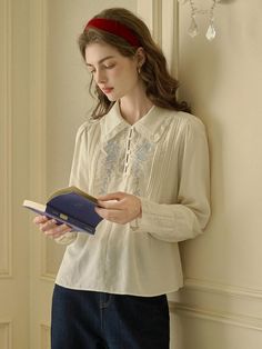 This Rose Embroidery Shirt exudes vintage charm, featuring intricate embroidery on the front that brings a touch of elegance to the classic silhouette. Its soft collar and button-down design make it a versatile piece that pairs well with both formal and casual attire. Delicate lace detailing along the cuffs and collar adds a sophisticated and timeless finish. - Crafted with attention to detail, the shirt includes pin-tuck accents along the front panel.- The back of the shirt is kept simple, ensuring the focus remains on the beautiful embroidery work.- It's designed with long sleeves and buttoned cuffs, offering a tailored and comfortable fit.- Made from a breathable fabric, it is ideal for both cool and warm weather, transitioning effortlessly between seasons. Feminine Floral Embroidered Blouse With Collar, Feminine Collared Blouse With Floral Embroidery, Floral Embroidered Blouse With Collar, Elegant Cream Tops With Intricate Embroidery, Formal Long Sleeve Tops With Intricate Embroidery, Elegant Long Sleeve Embroidered Shirt, Floral Embroidery Collared Blouse For Work, Classic Embroidered Tops For Fall, Elegant Embroidered Formal Tops