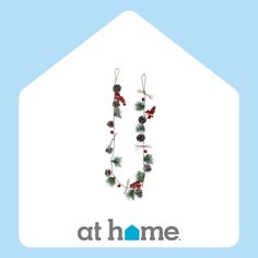 the logo for at home with pine cones and berries hanging from it's side