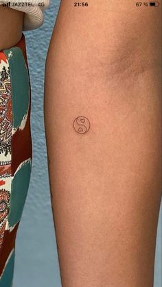 a woman's leg with a small tattoo on the lower half of her thigh