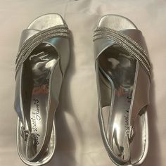 I Bought These Shoes To Wear For My Daughter’s Wedding And Wound Up Wearing Something Else. I Tried Them On And Walked Around In Them But Never Wore Them For Any Extended Period Of Time. They Are A Silver Slingback With Crystal Rhinestones Across The Top. They Have The Dance Flex Outsole. Heel Height Is Approximately 2.5”. Synthetic Wedding Shoes With Round Toe, Synthetic Closed Toe Wedding Shoes, Wedding Sandals With Round Toe In Synthetic Material, Formal Closed Toe Synthetic Wedding Shoes, Formal Synthetic Closed-toe Wedding Shoes, Formal Slip-on Wedding Shoes For Spring, Spring Formal Wedding Shoes Slip-on, Spring Formal Wedding Slip-on Shoes, Formal Spring Wedding Slip-on Shoes