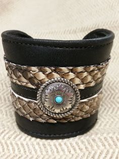 This is a 2 1/2 " wide cuff bracelet made with soft black cowhide with genuine python trim, and a beautiful concho accent. Buckle closure in back makes it adjustable.It is a very well made piece of wearable art for any occasion. Western Leather Concho Cuff Bracelet, Black Concho Jewelry For Rodeo, Southwestern Leather Concho Cuff Bracelet, Unique Leather Cuff Bracelet With Concho, Southwestern Adjustable Leather Cuff Bracelet, Adjustable Southwestern Leather Cuff Bracelet, Handmade Western Cuff Bracelet, Leather Cuff Bracelet With Concho, Leather Concho Cuff Bracelet