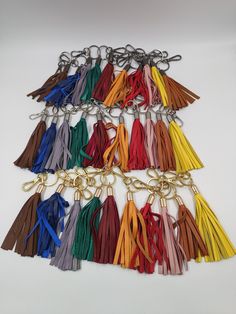 a bunch of tassels that are on a white surface with one keychain in the middle