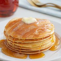 a stack of pancakes covered in syrup and butter