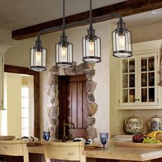 three lights hanging over a kitchen island with chairs and fruit on the table in front of it