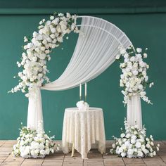 a white wedding arch decorated with flowers