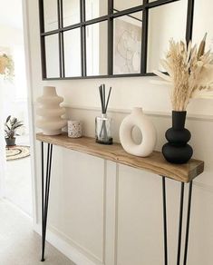 a wooden table topped with vases and mirrors