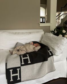 a baby sleeping on top of a black and white blanket next to a stair case