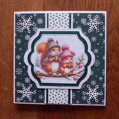 a christmas card with an image of two squirrels and snowflakes on it