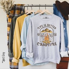 Our Life is better by the campfire pullover is the perfect addition to any wardrobe! We create custom sweatshirts with great designs for everyone's liking. If you don't find the size or colour you would like, please message us and we will be happy to accommodate! PRODUCT We use the finest premium Gildan 18000 crewneck sweatshirts for you, they are feather soft and very breathable with a good stretch. These sweatshirts are known for their great quality and much loved by our consumers. SIZING This Cozy Crew Neck Sweatshirt For Outdoor, Long Sleeve T-shirt For Fall Adventure, Crew Sweatshirt For Outdoor Activities In Fall, Graphic Print T-shirt For Fall Camping, Long Sleeve T-shirt With Letter Print For Camping, Fall Long Sleeve Tops For Camping, Long Sleeve Tops For Fall Camping, Fall Camping T-shirt With Letter Print, Fall Hiking Sweatshirt With Letter Print