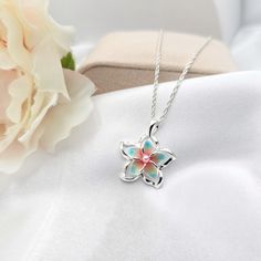 This Sterling Silver Rainbow Plumeria Necklace is the perfect accessory for anyone looking to add a touch of Hawaiian-inspired style to their look. Crafted with 925 sterling silver, this beautiful necklace features a colorful plumeria flower surrounded by intricate detail. The ideal beach gift, this plumeria pendant is sure to make a lasting impression. - Comes ready to wear on a 925 sterling silver chain of your choice length. Comes standard on a box style chain.  - solid sterling silver plumeria flower pendant accented with a faux pearl   Approx 20 mm in size Custom made to order so yours may look slightly different from the above pictures. Due to different monitors and settings colors may appear slightly different. Plumeria Necklace, Hawaiian Summer, Tropical Jewelry, Plumeria Flowers, Hawaiian Jewelry, Jewelry Beach, Gift Flower, Beach Getaway, Floral Jewelry